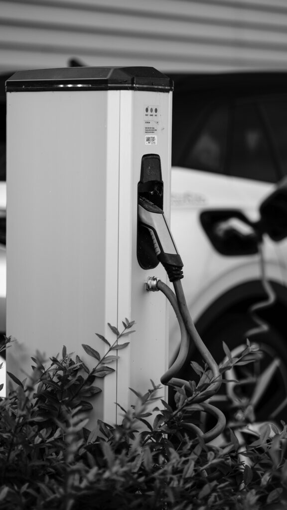 Monochrome image of an electric vehicle charging station in an urban setting.