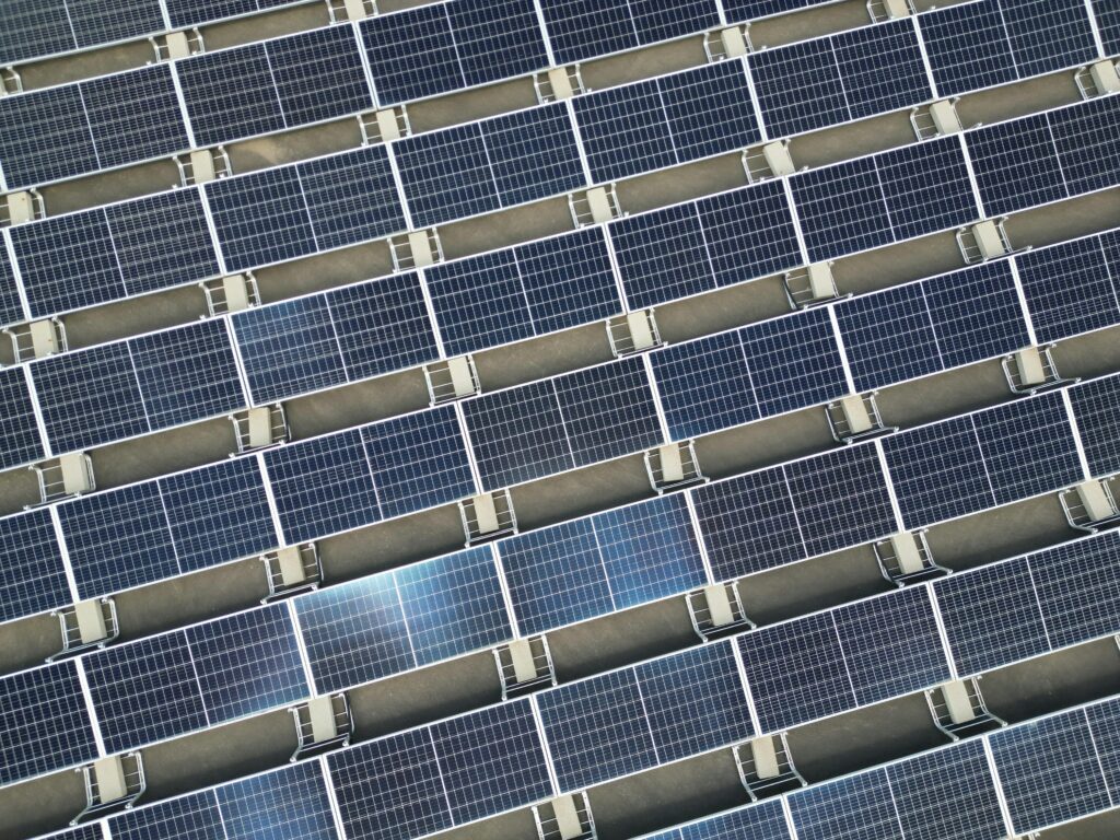 Array of solar panels in grid layout viewed from above promoting renewable energy